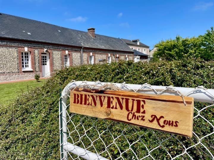 Une pancarte portant l'inscription « Bienvenue chez nous » est accrochée à une clôture devant un bâtiment en briques.