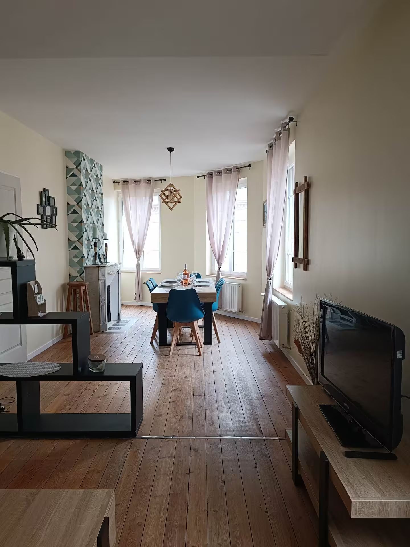 Un salon avec une table et des chaises et une télévision écran plat.