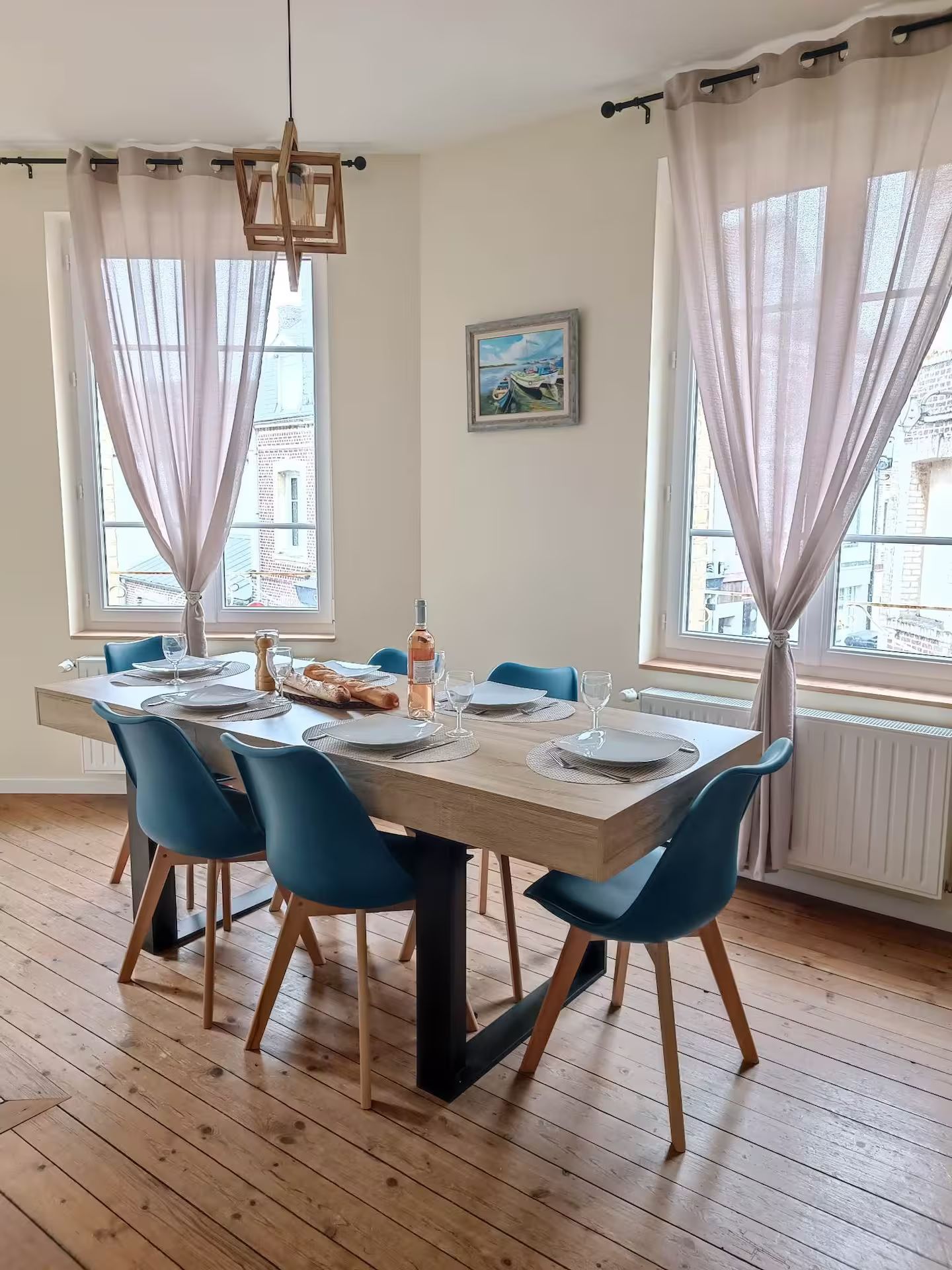 Une salle à manger avec une table et des chaises et une bouteille de vin.