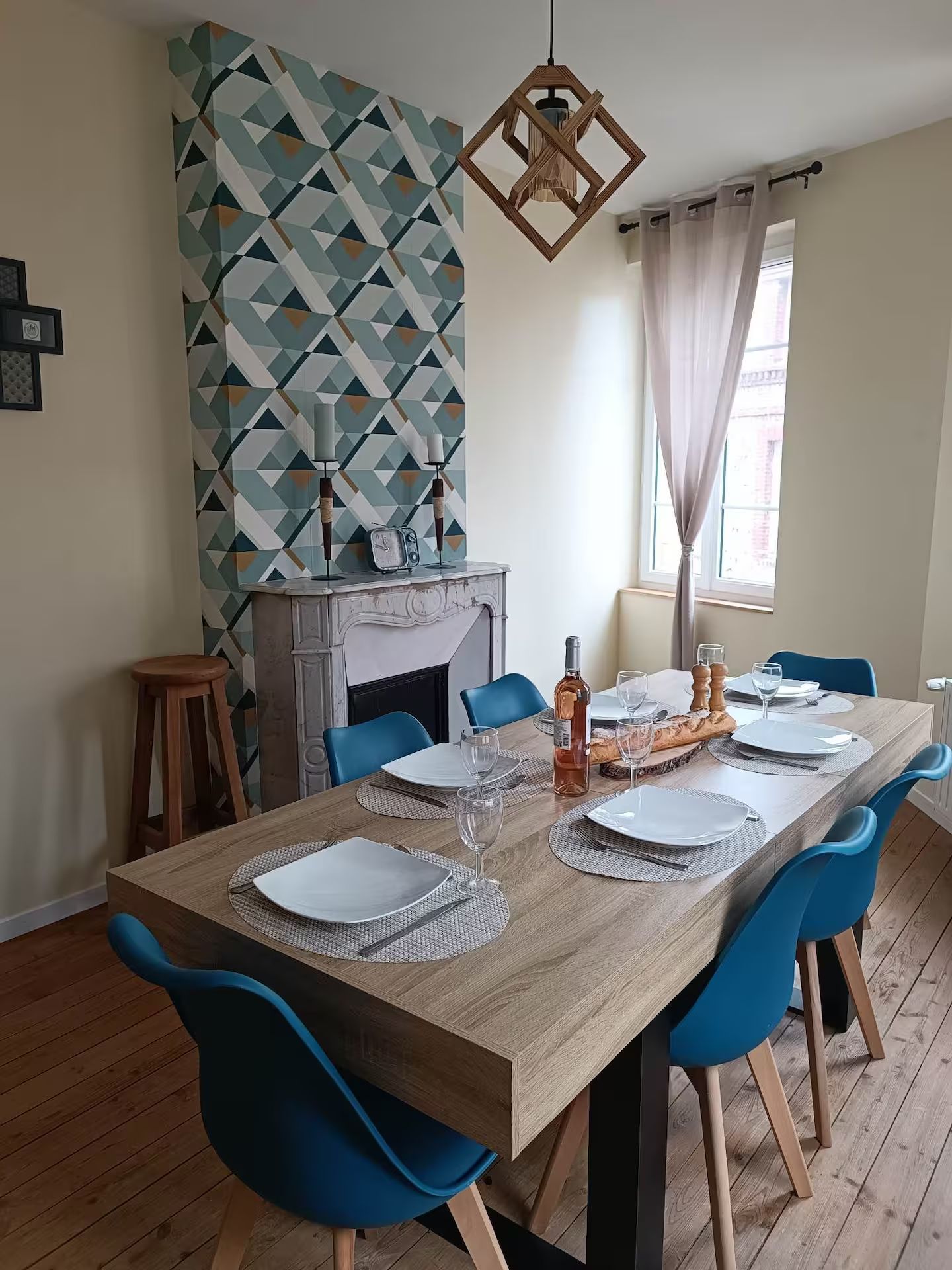 Une table de salle à manger avec des chaises bleues et des assiettes dessus.