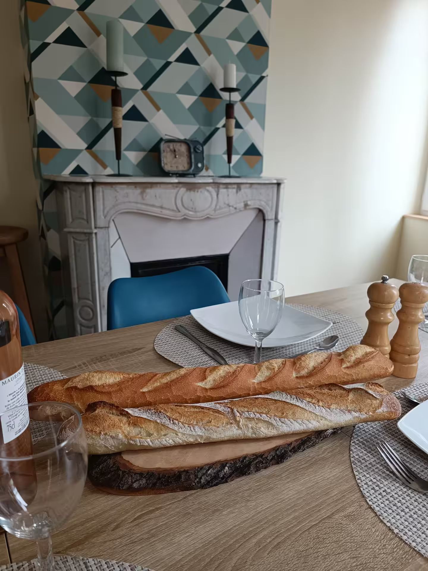Une longue miche de pain est posée sur une planche à découper en bois sur une table.