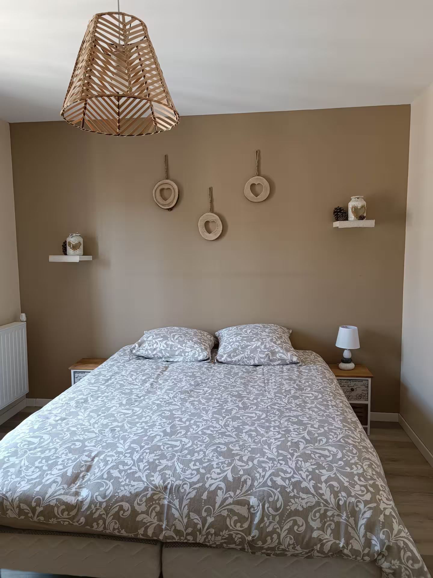 Il y a un lit au milieu de la pièce avec une lampe suspendue au plafond.