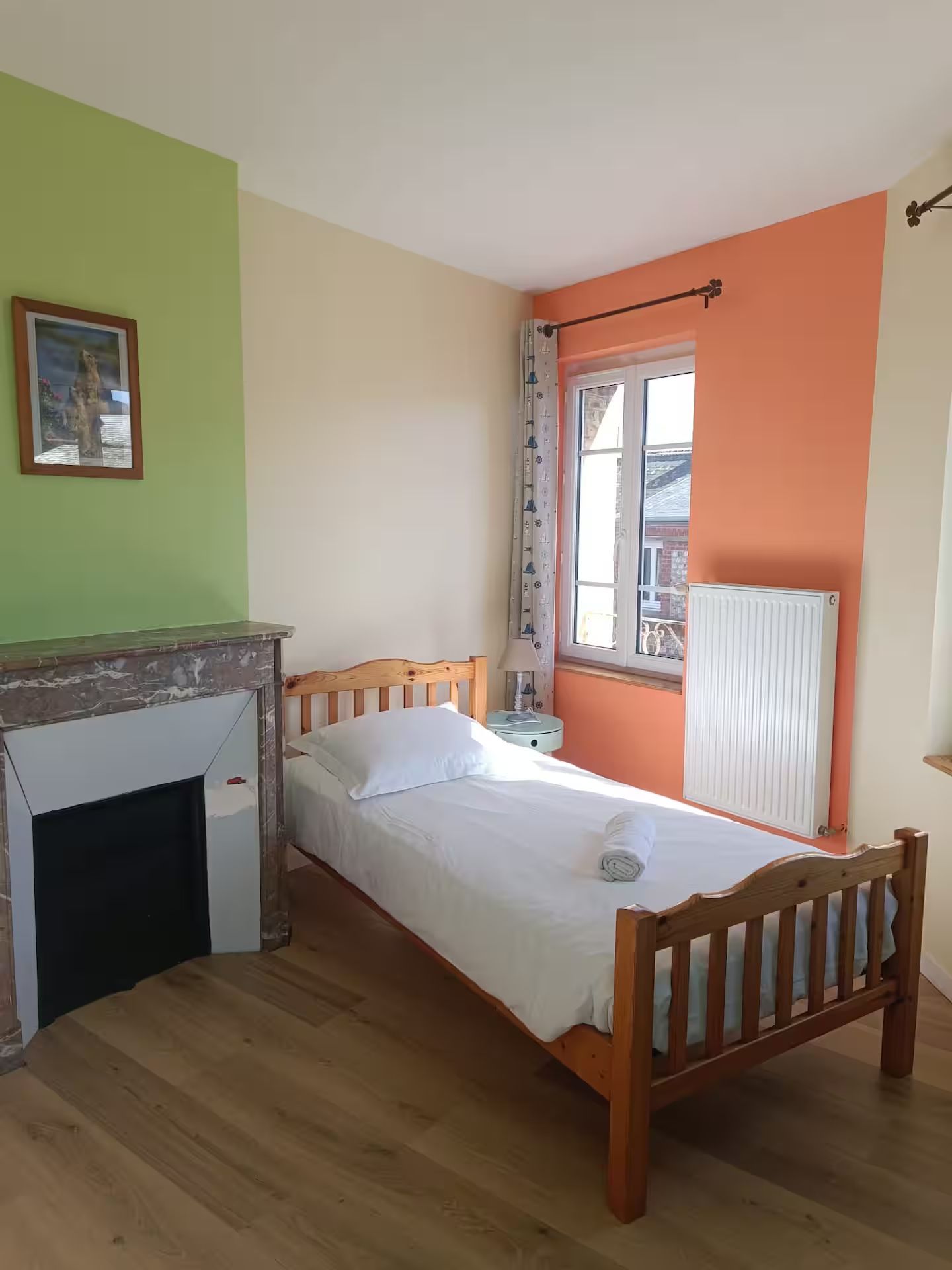 Une chambre avec un lit simple et une cheminée.