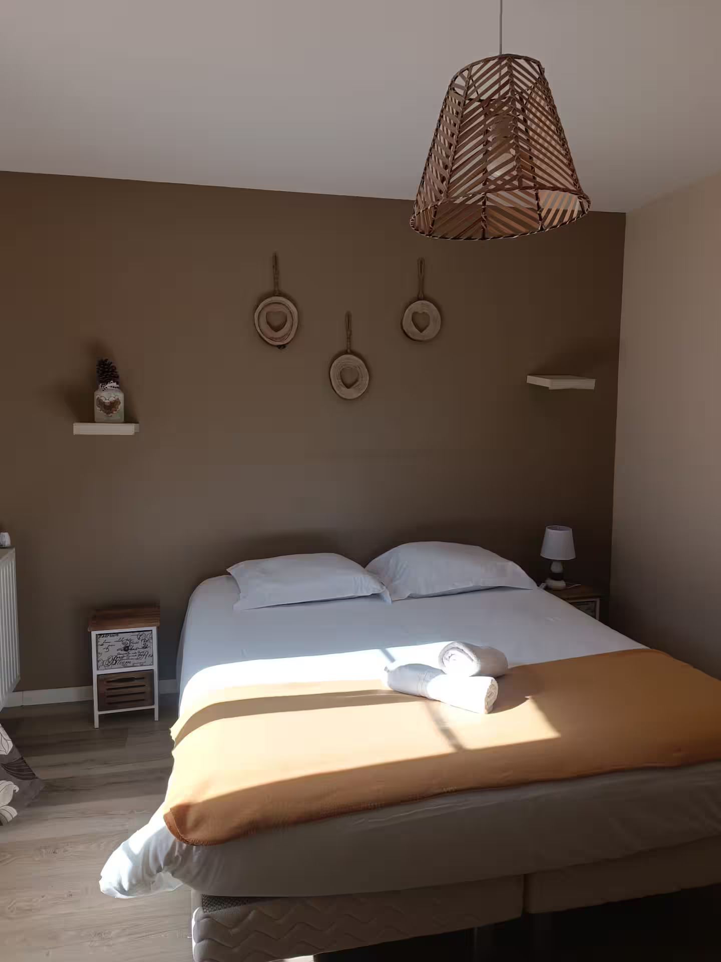 Une chambre avec un lit et une lampe suspendue au plafond