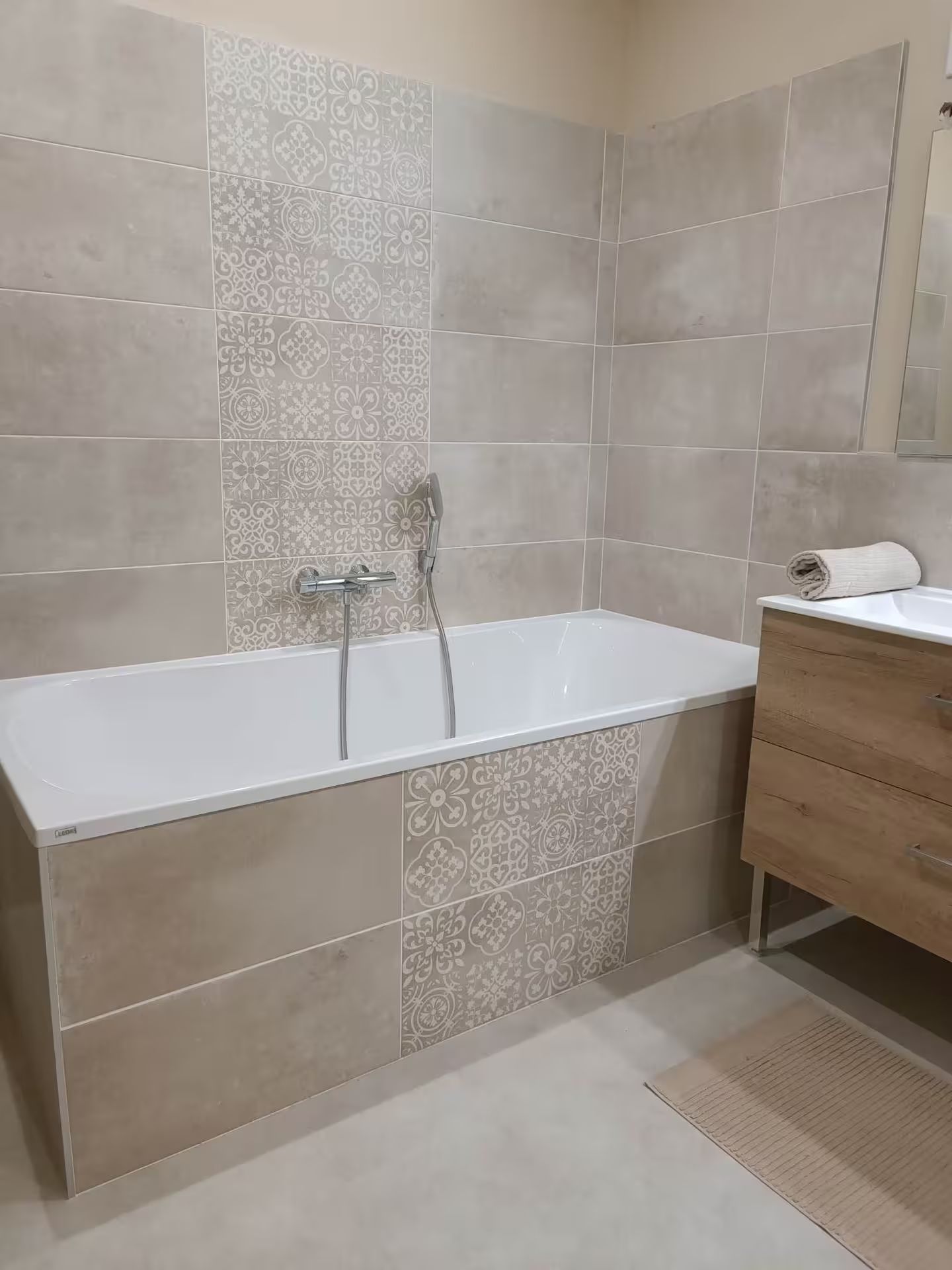 Une salle de bain avec baignoire, lavabo et miroir.