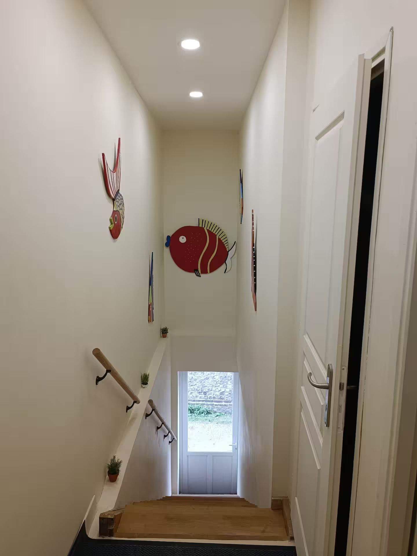 Un long couloir avec des escaliers menant à une porte