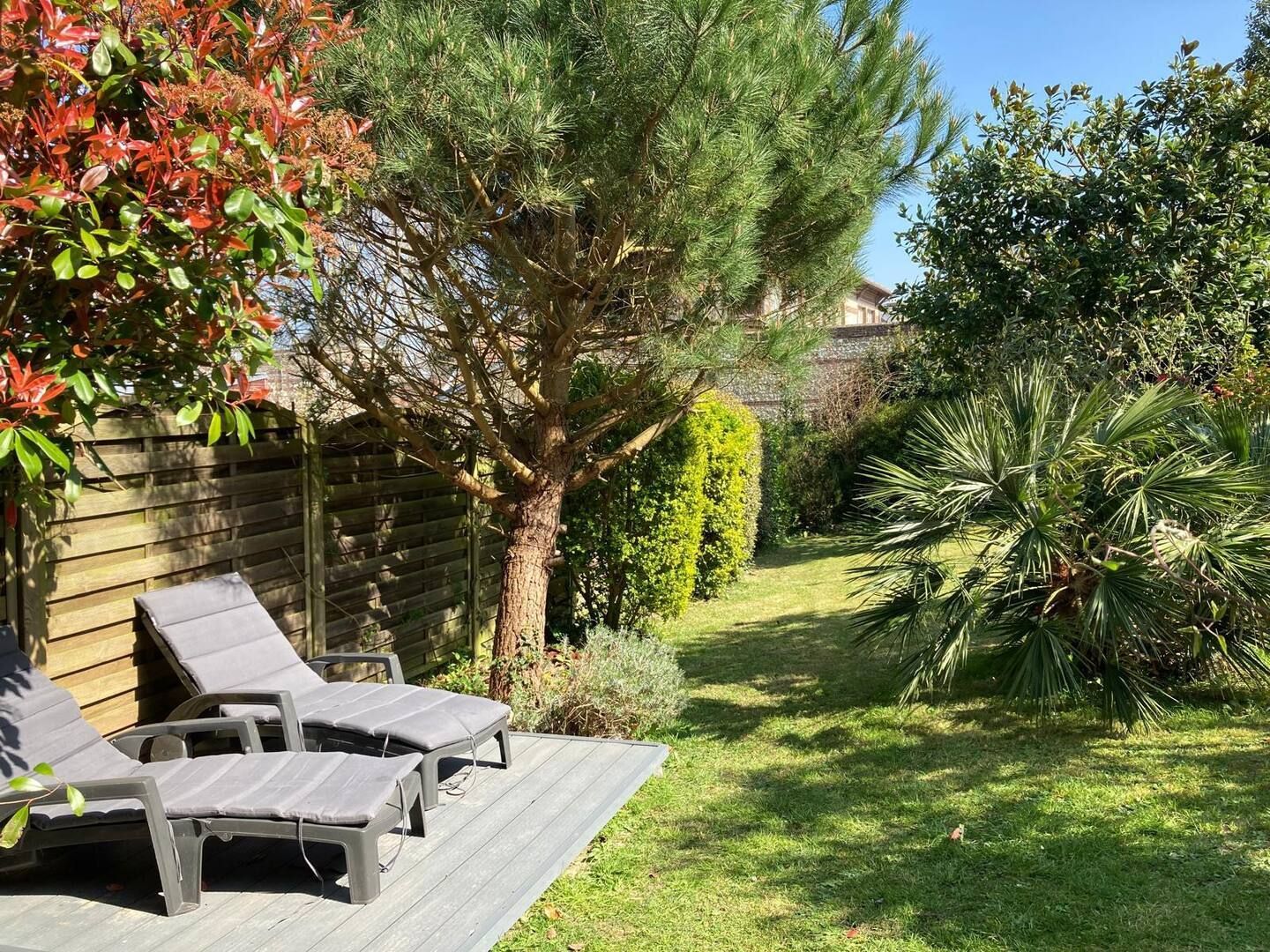 Il y a deux chaises longues sur la terrasse dans l'arrière-cour.