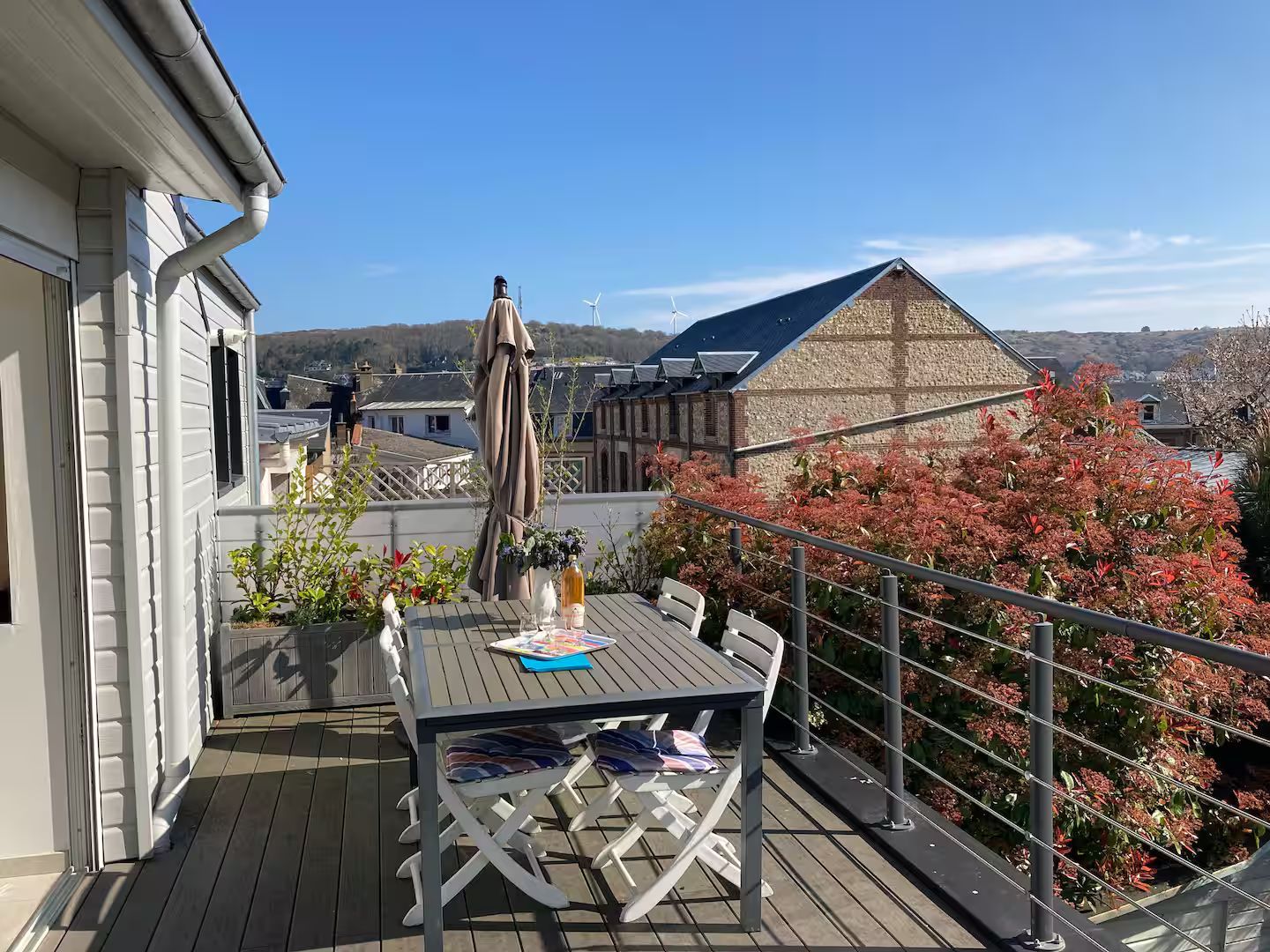 Il y a une table et des chaises sur le balcon avec vue sur la ville.