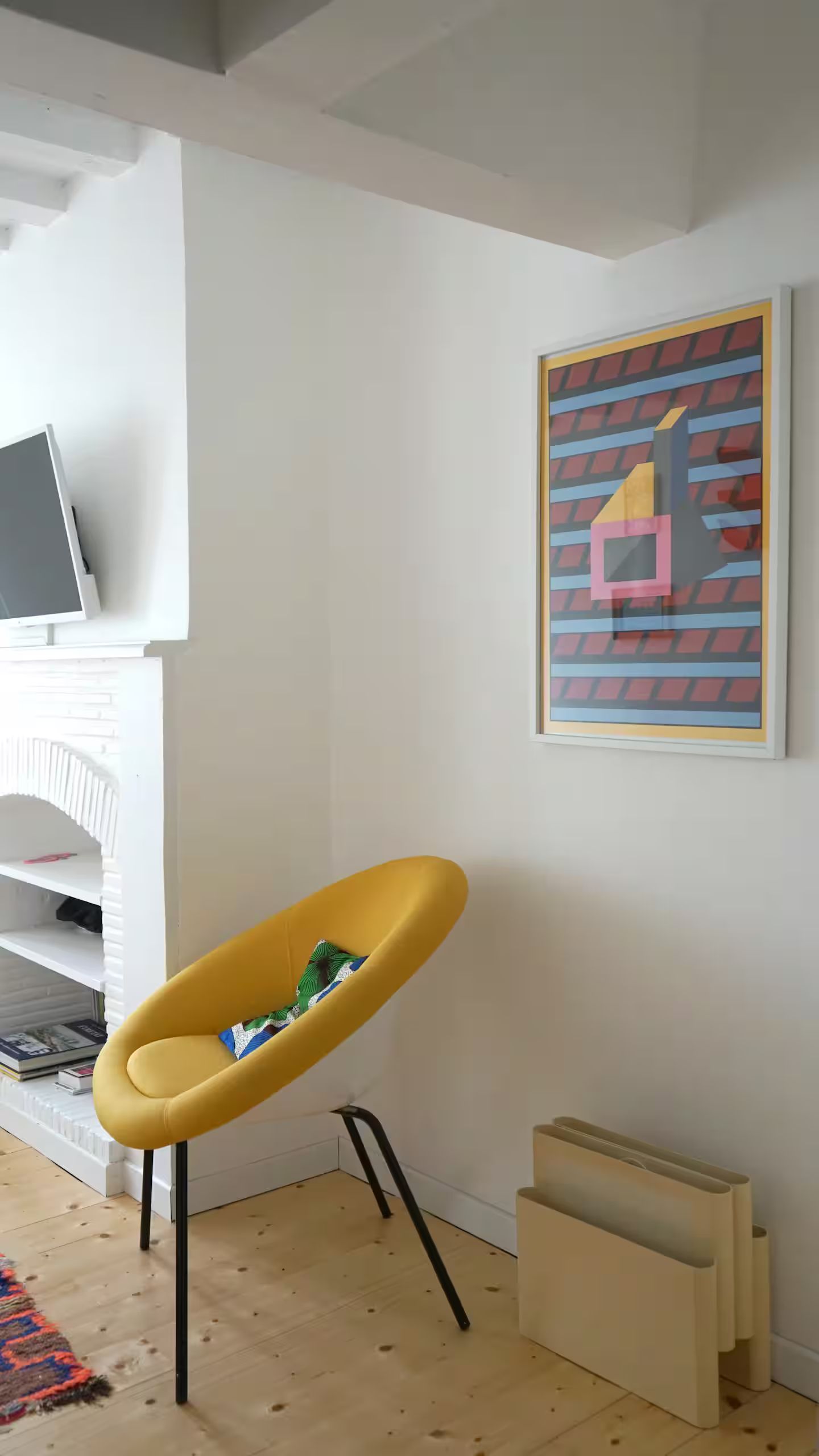 Une chaise jaune est assise dans un salon à côté d'une cheminée.
