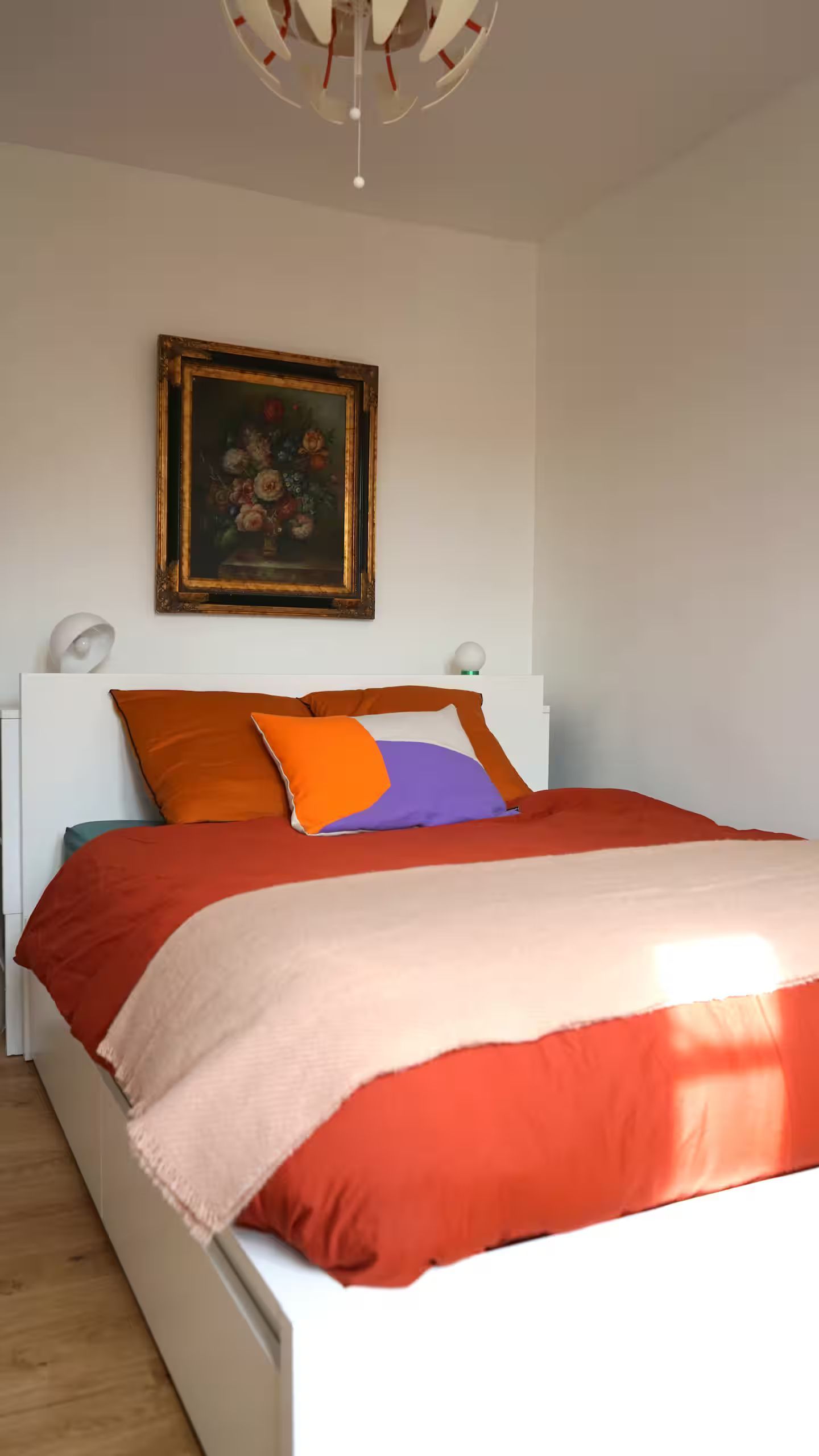 Une chambre avec un lit et un tableau sur le mur au-dessus