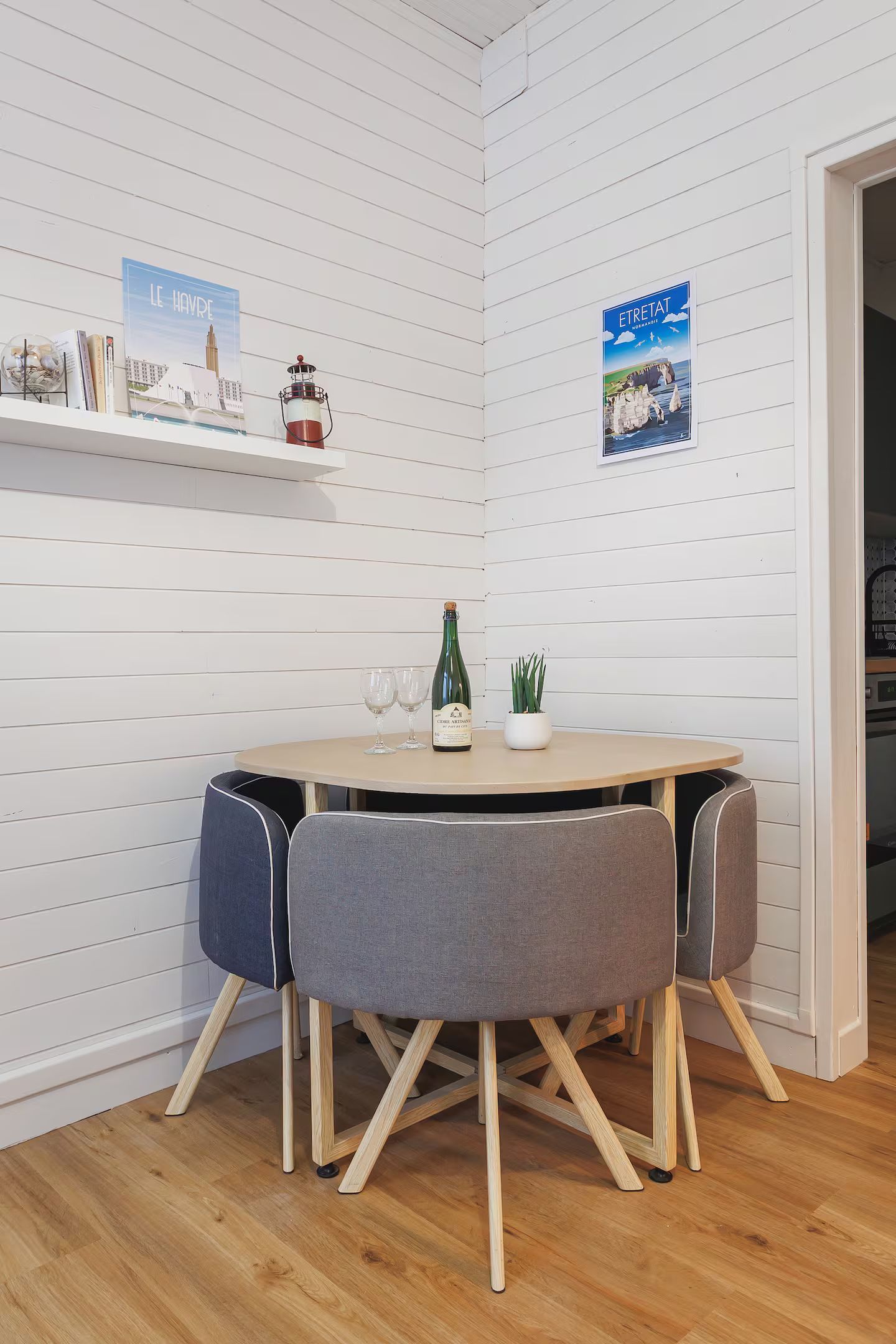 Il y a une table et des chaises dans le coin de la pièce.