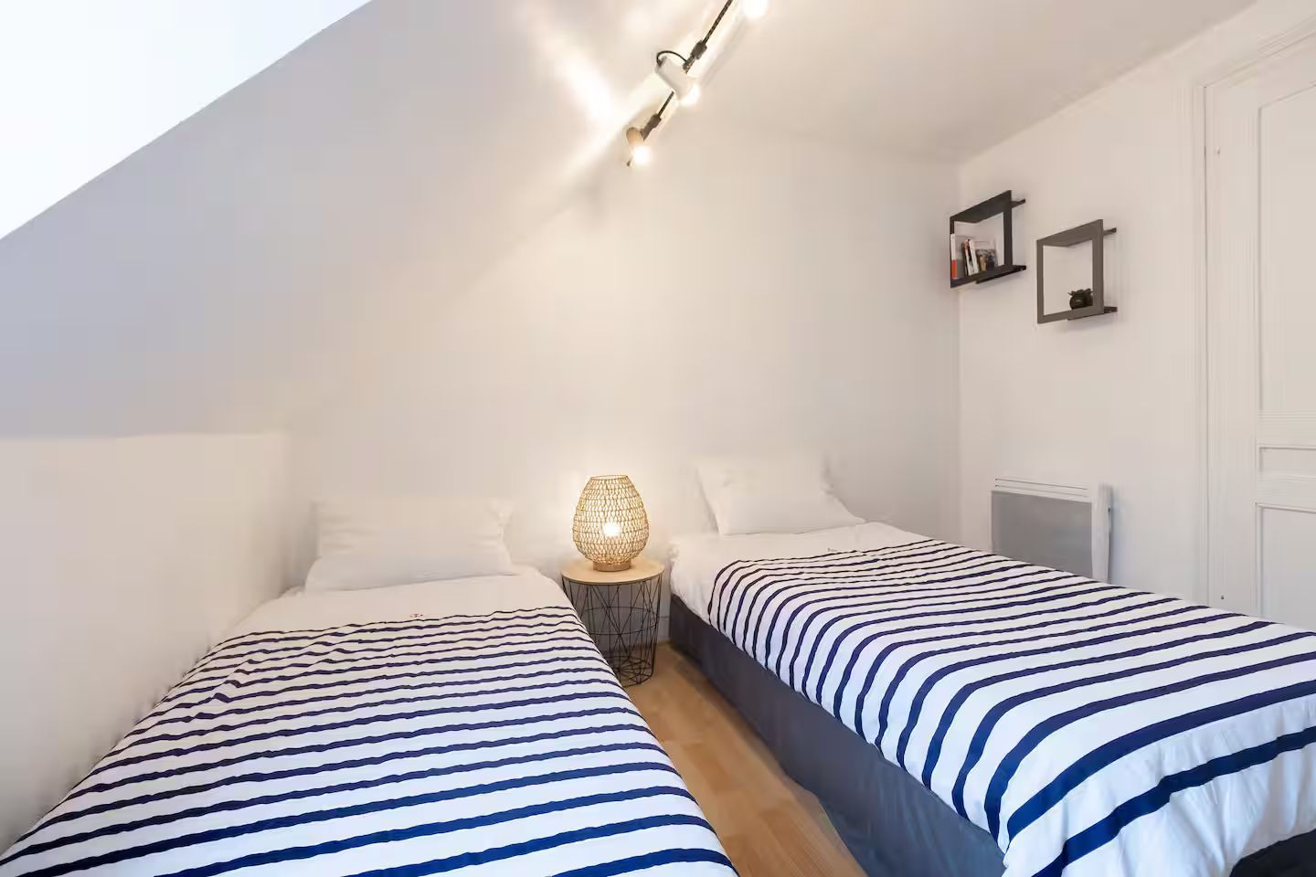 Une chambre avec deux lits et une lampe sur la table de nuit.