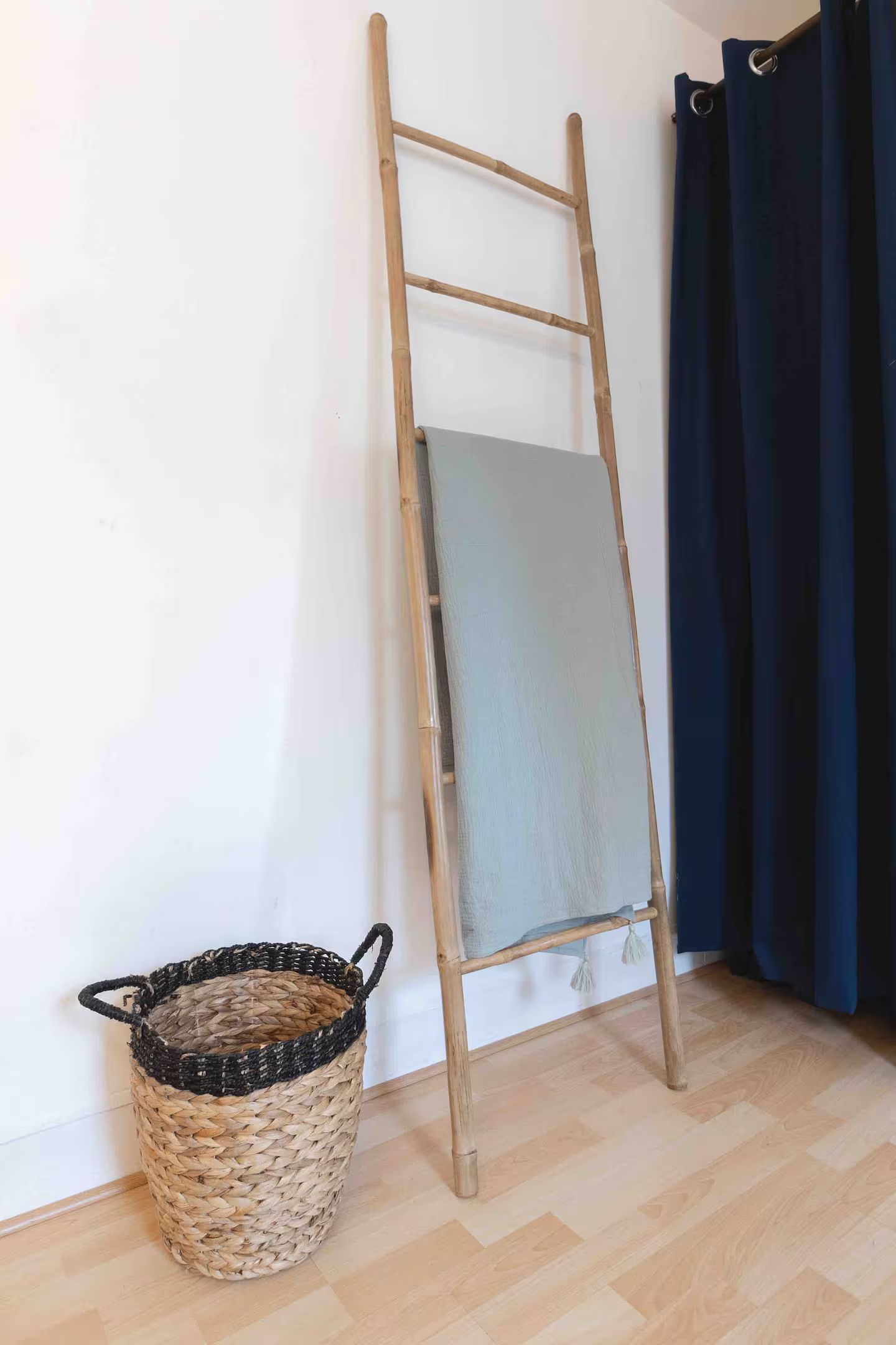 Une échelle avec une couverture dessus se trouve à côté d'un panier.