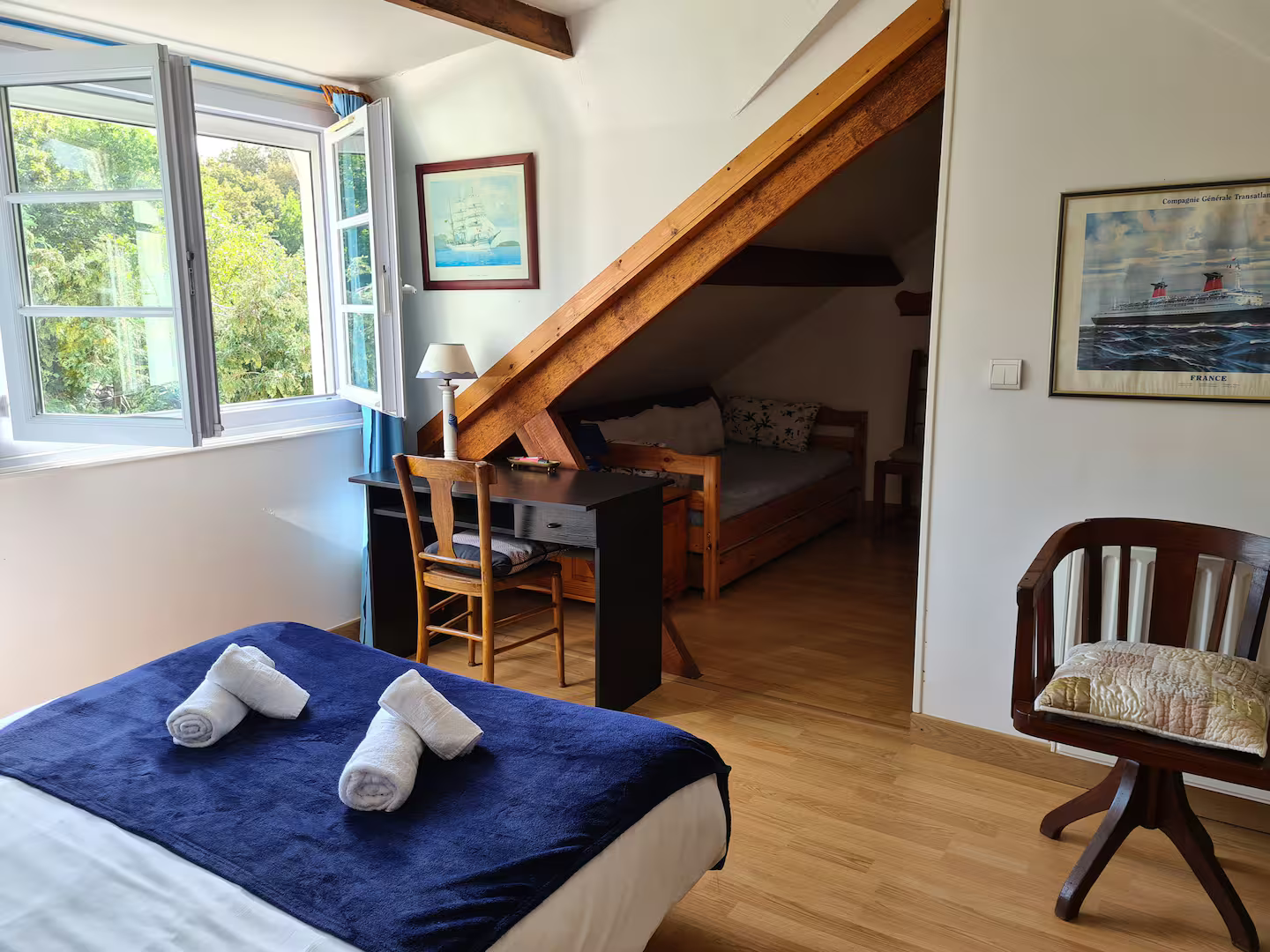 Une chambre avec un lit, une chaise, un bureau et une fenêtre.