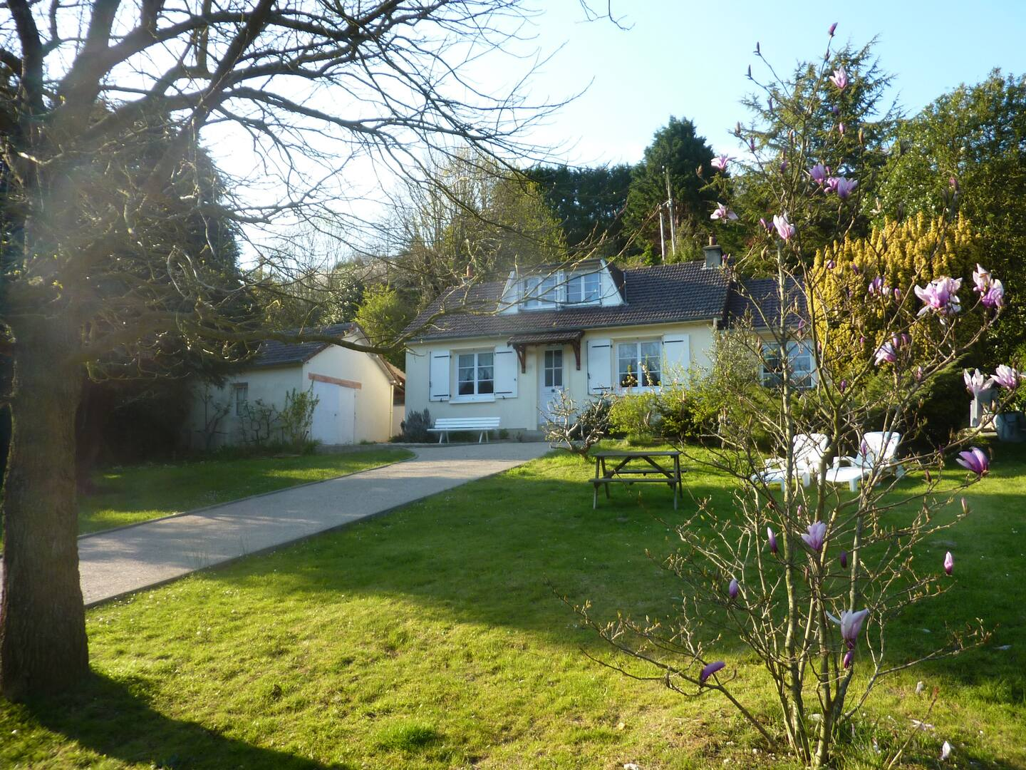 Une maison avec une table de pique-nique devant