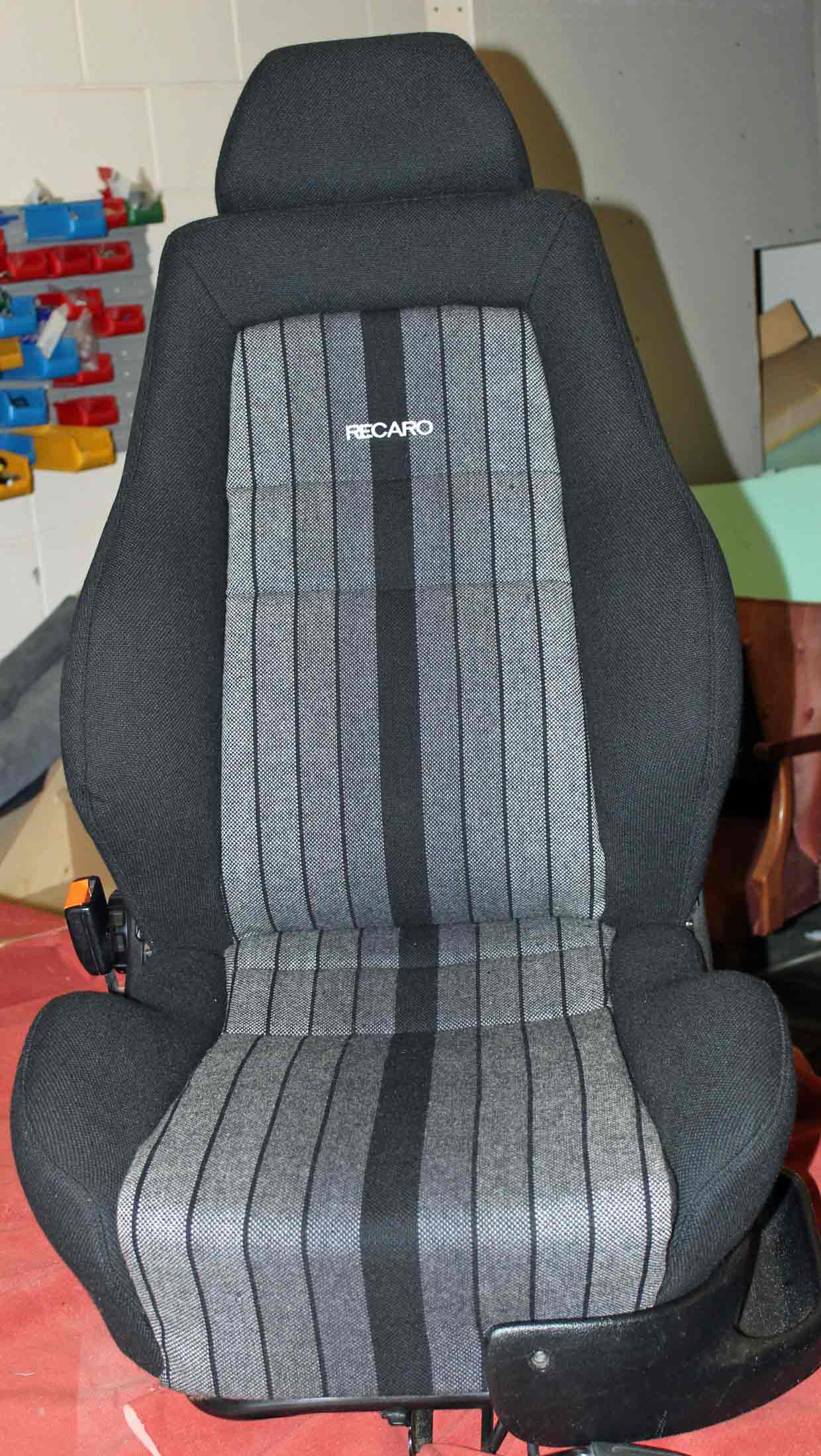 A black car seat with white stripes running down the middle.