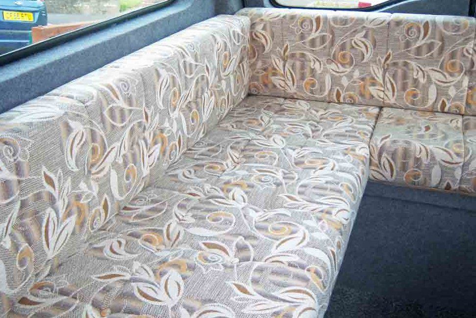 A motor home sofa with attractive floral cushions.
