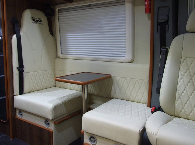 Motor home seats by a table with cream upholstering.