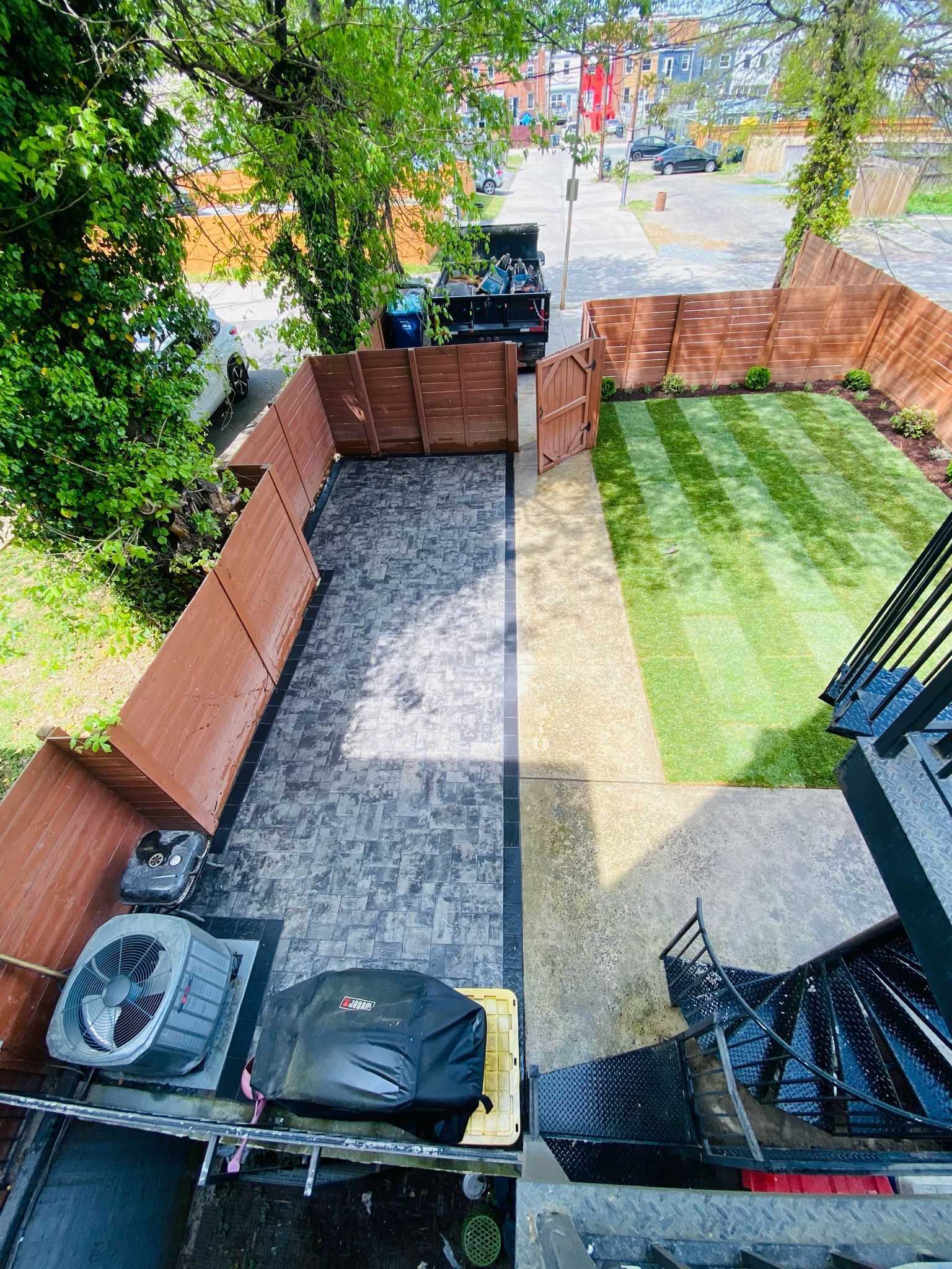 An aerial view of a backyard with a fence and a lawn