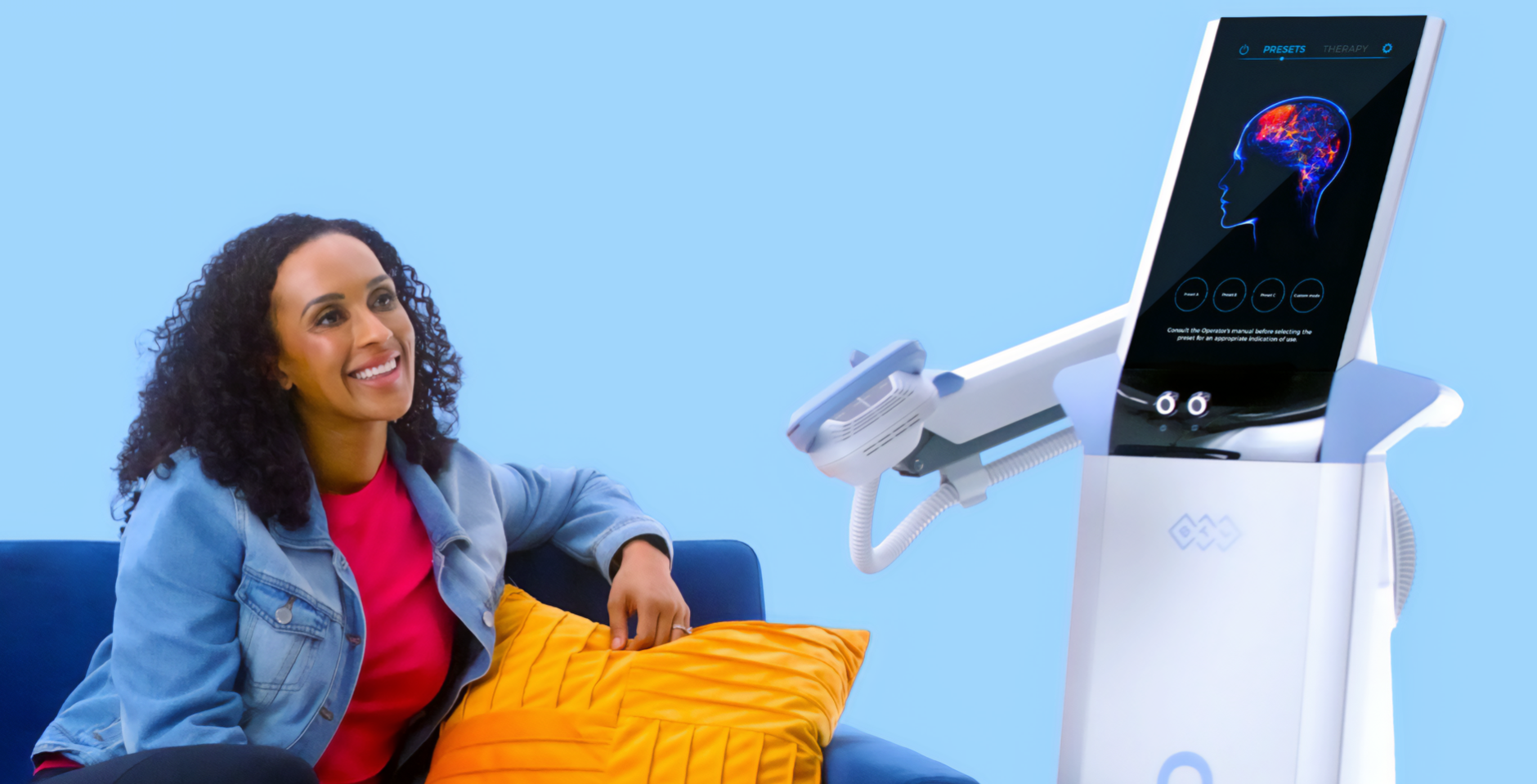 A woman is sitting on a couch next to a machine.