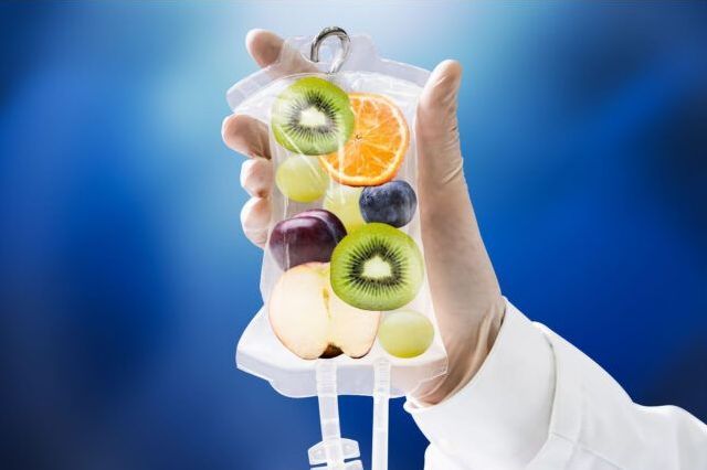 A person is holding a bag of fruit in their hand.