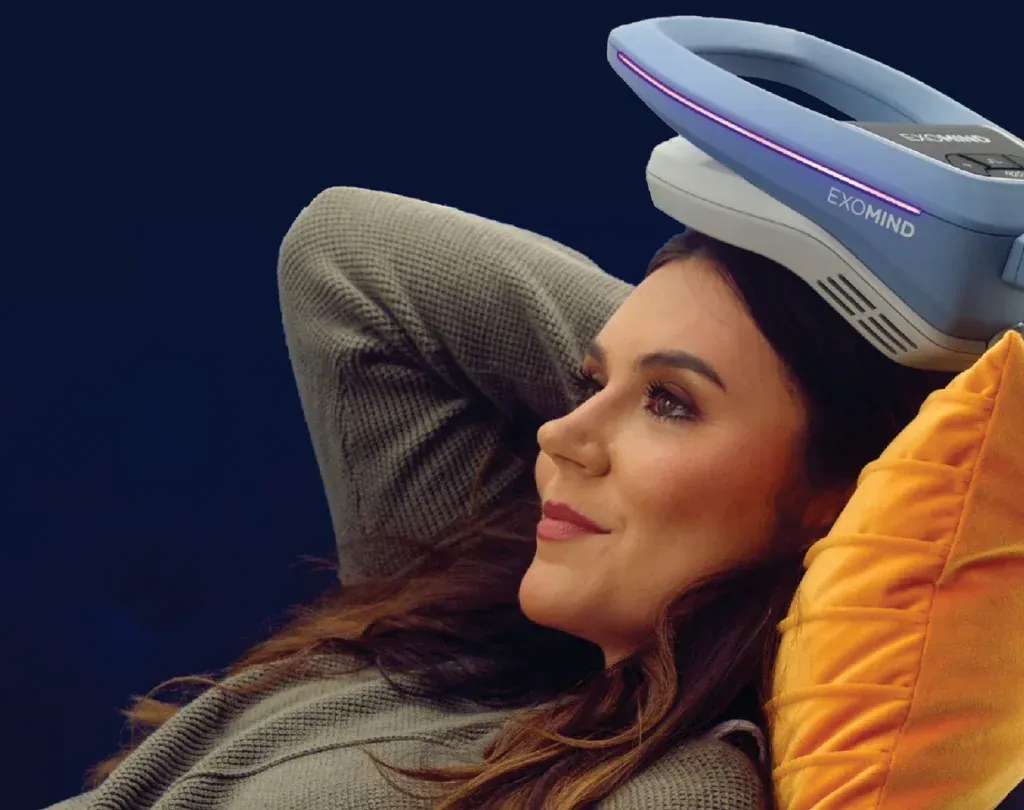 A woman is laying down with a device on her head that says evomind
