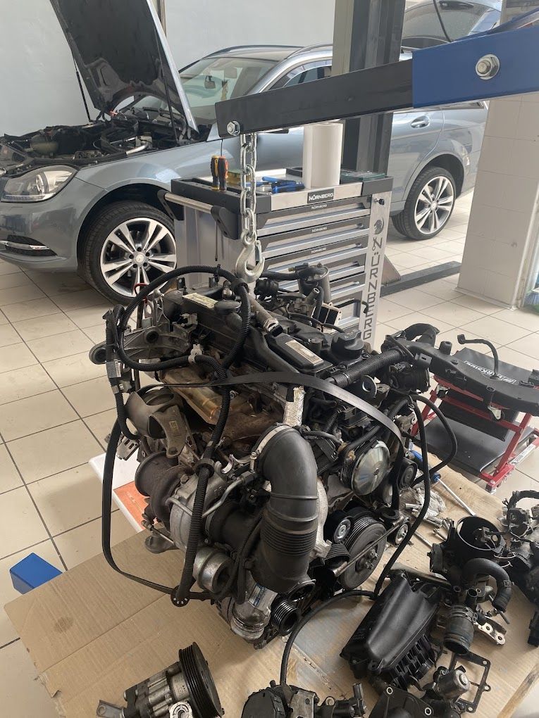 In un garage si sta riparando il motore di un'auto.