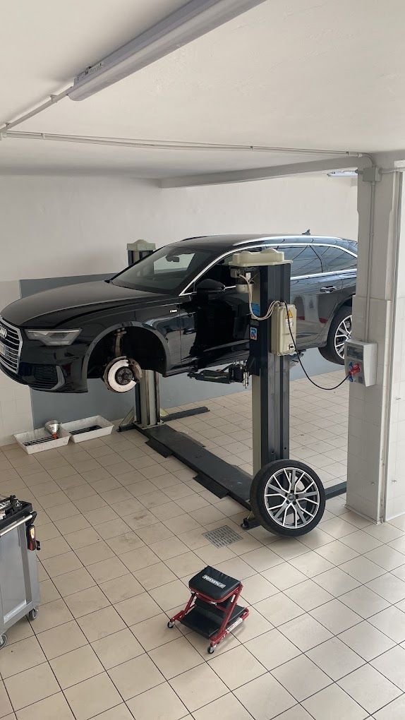 Un'auto è parcheggiata su un ponte sollevatore in un garage.