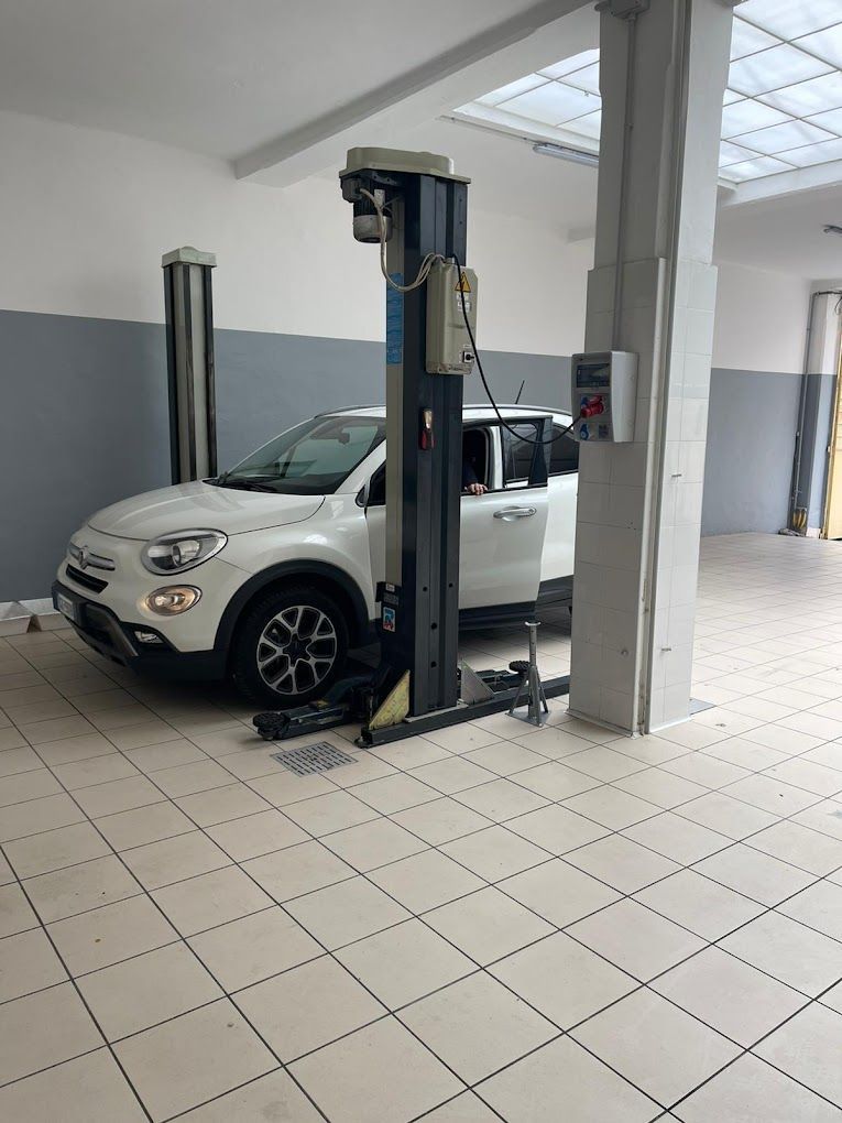 Un'auto bianca è parcheggiata su un ascensore in un garage.