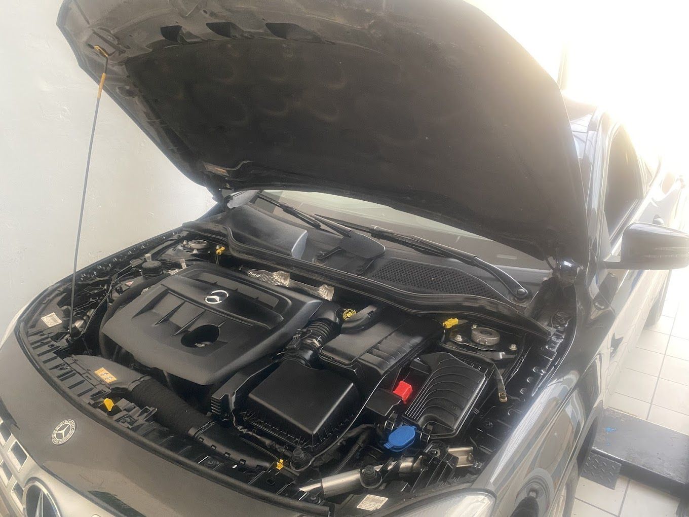 Il cofano di un'auto è aperto e mostra il motore