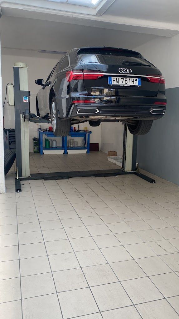 Un'auto è parcheggiata su un ponte sollevatore in un garage.