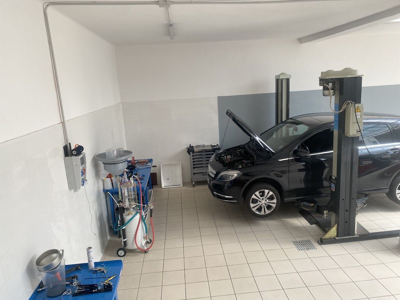 Un'auto è parcheggiata su un ponte sollevatore in un garage.