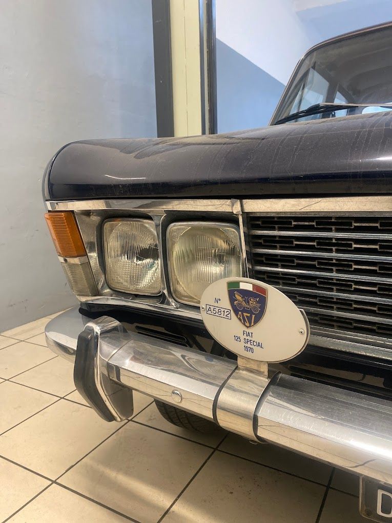 Un primo piano della parte anteriore di un'auto nera con targa.