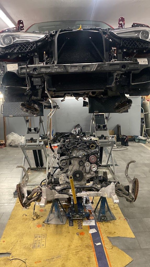 Un'auto viene riparata in un garage con il motore smontato.