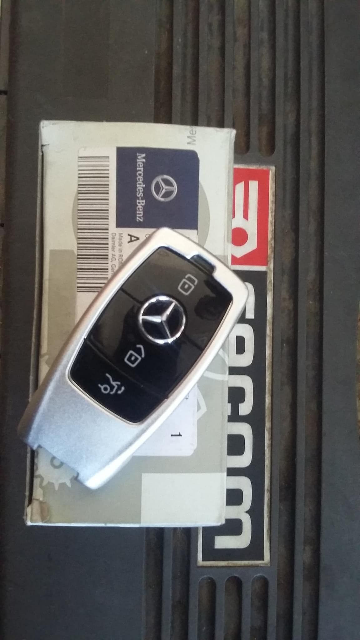 Un portachiavi mercedes è appoggiato sopra una scatola.