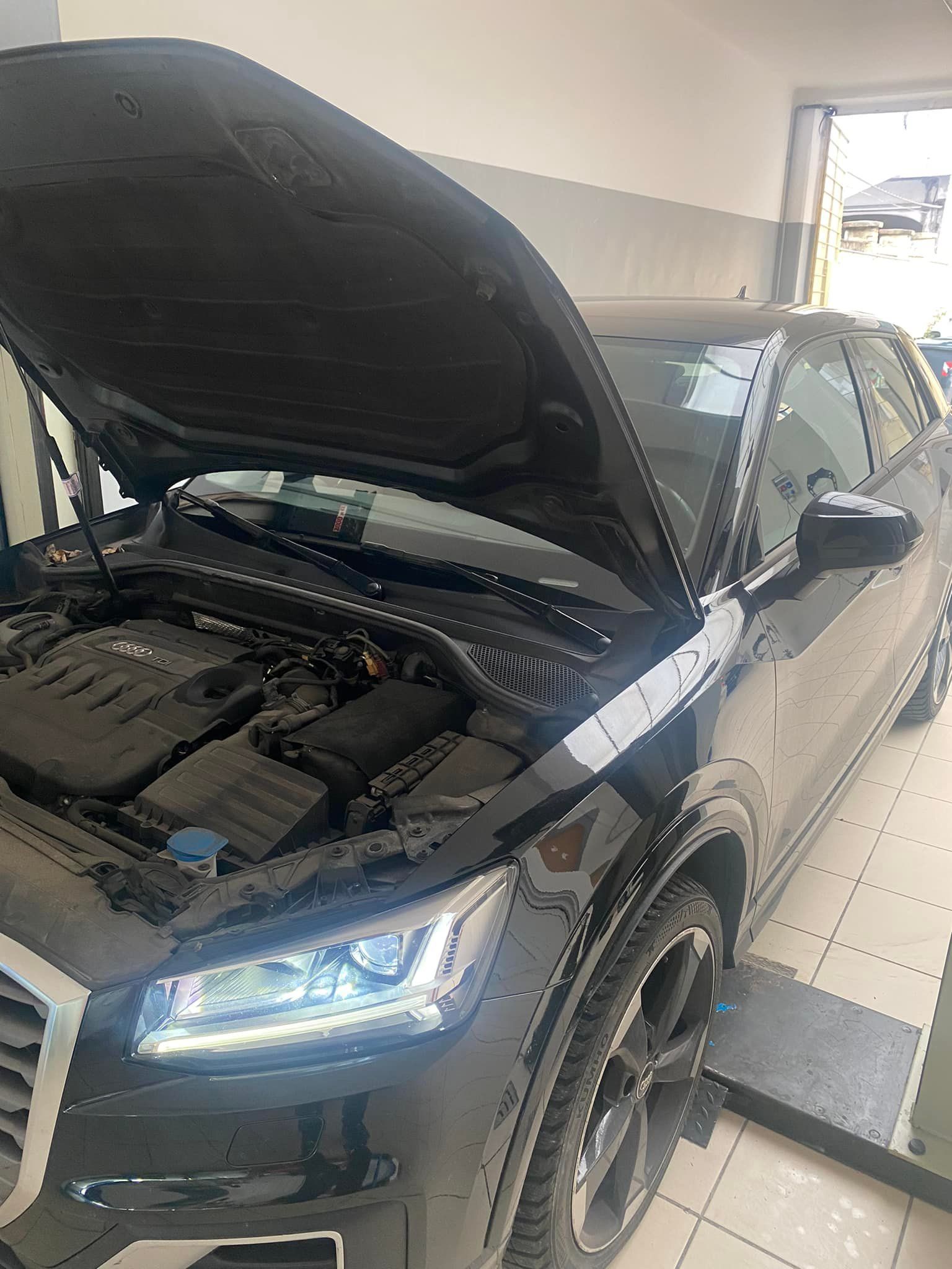 Il cofano di un'auto è aperto in un garage.