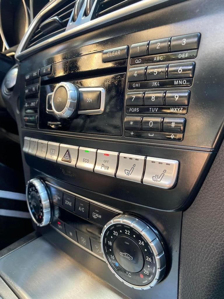 Un primo piano del cruscotto di un'auto con molti pulsanti e manopole.