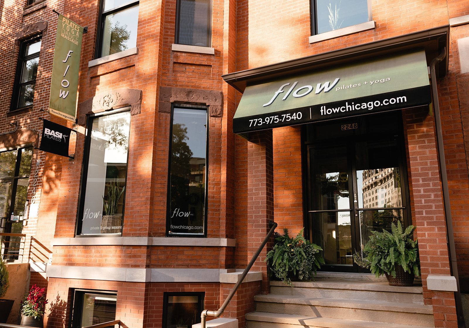 A brick building with a green awning that says Flow Chicago 