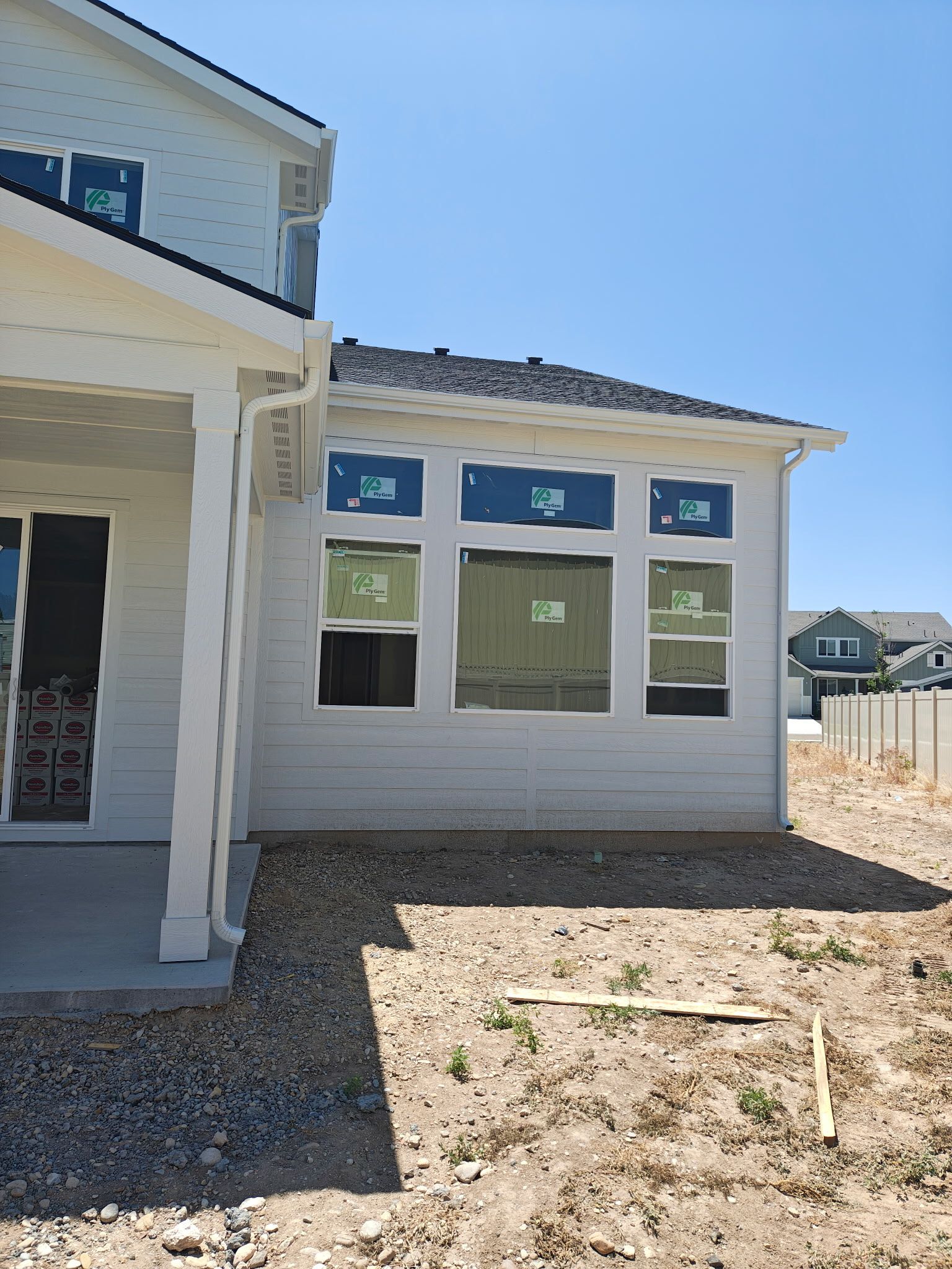 New construction home exterior with windows covered in protective film.