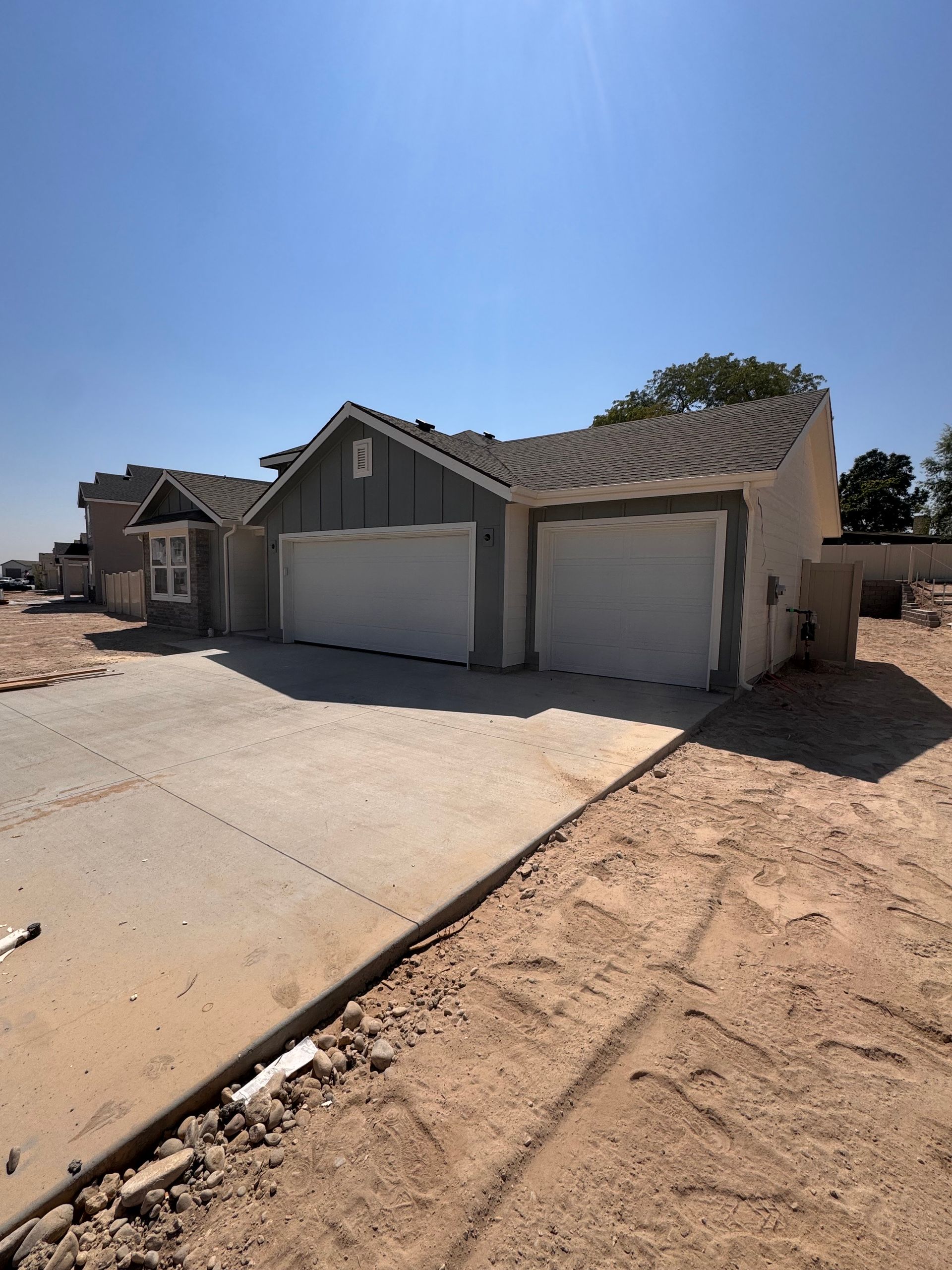 A two-car garage on a house under construction; a driveway is in front.