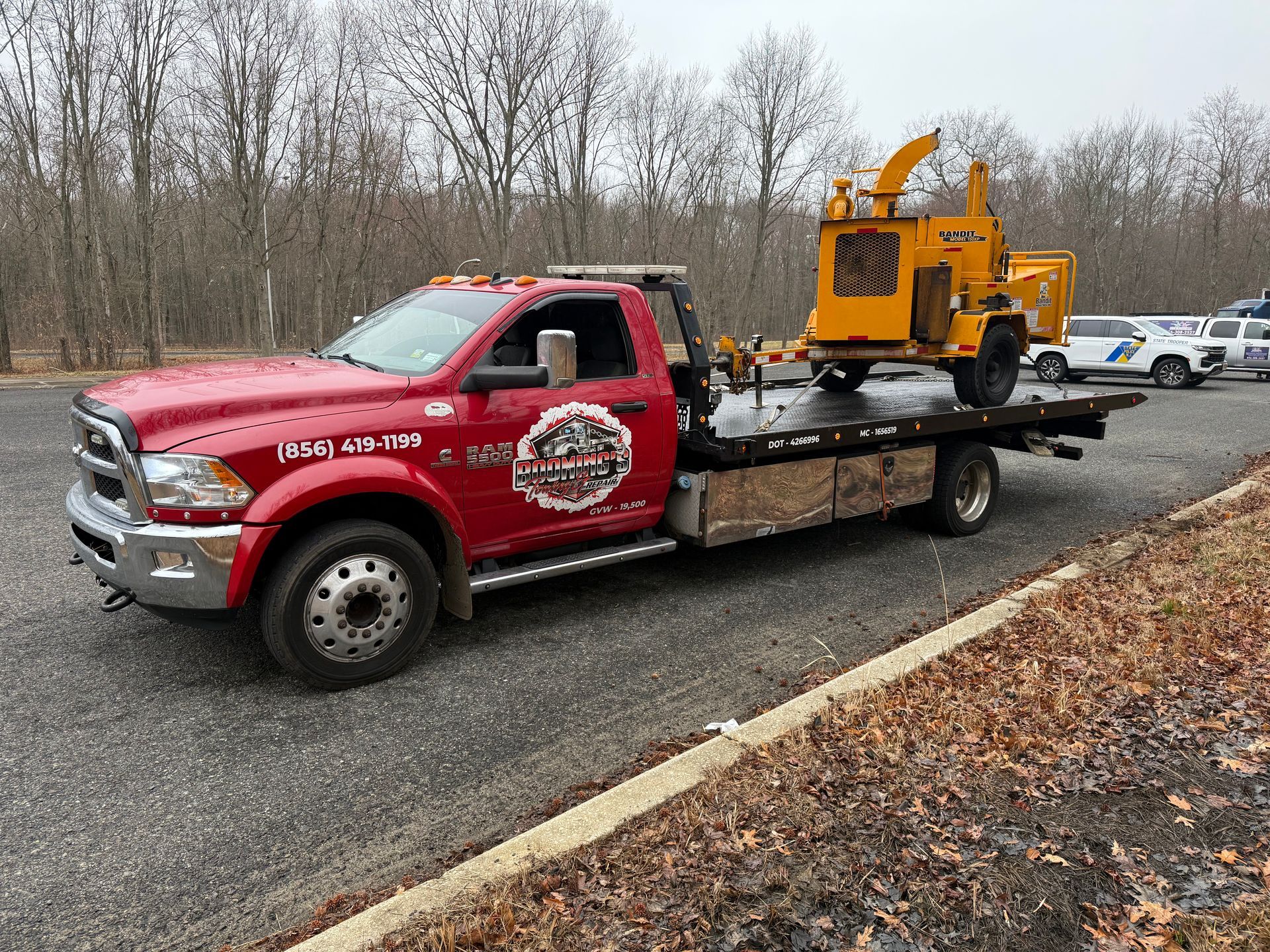 A tractor is being transported on a trailer on a highway.