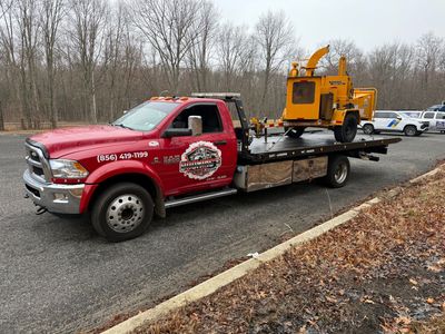 A truck is carrying a large excavator on a trailer.