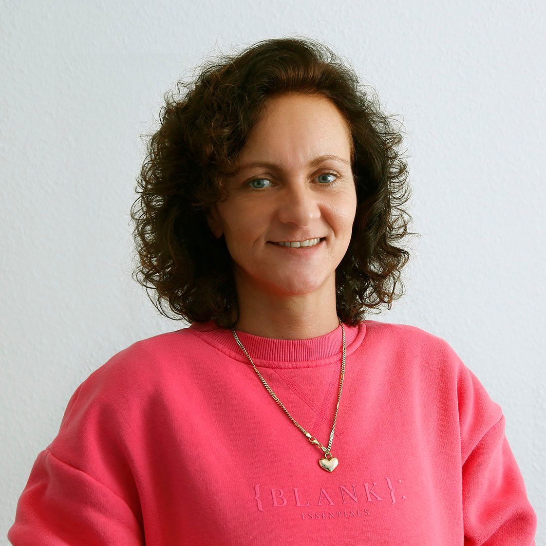 eine Frau trägt einen rosa Pullover mit der Aufschrift blank