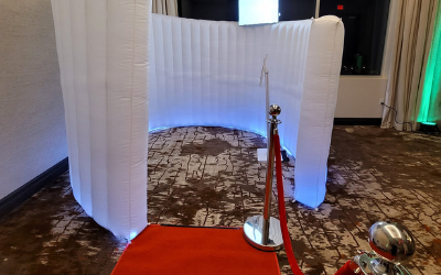 White curved panels around a circular stone floor display, with red ropes and a mirrored sphere on the right.