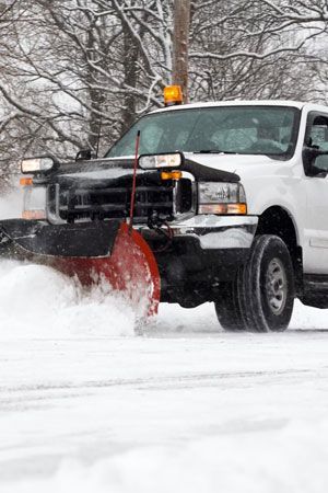 White snowplow truck White snowplow truck clearing a snowy road.