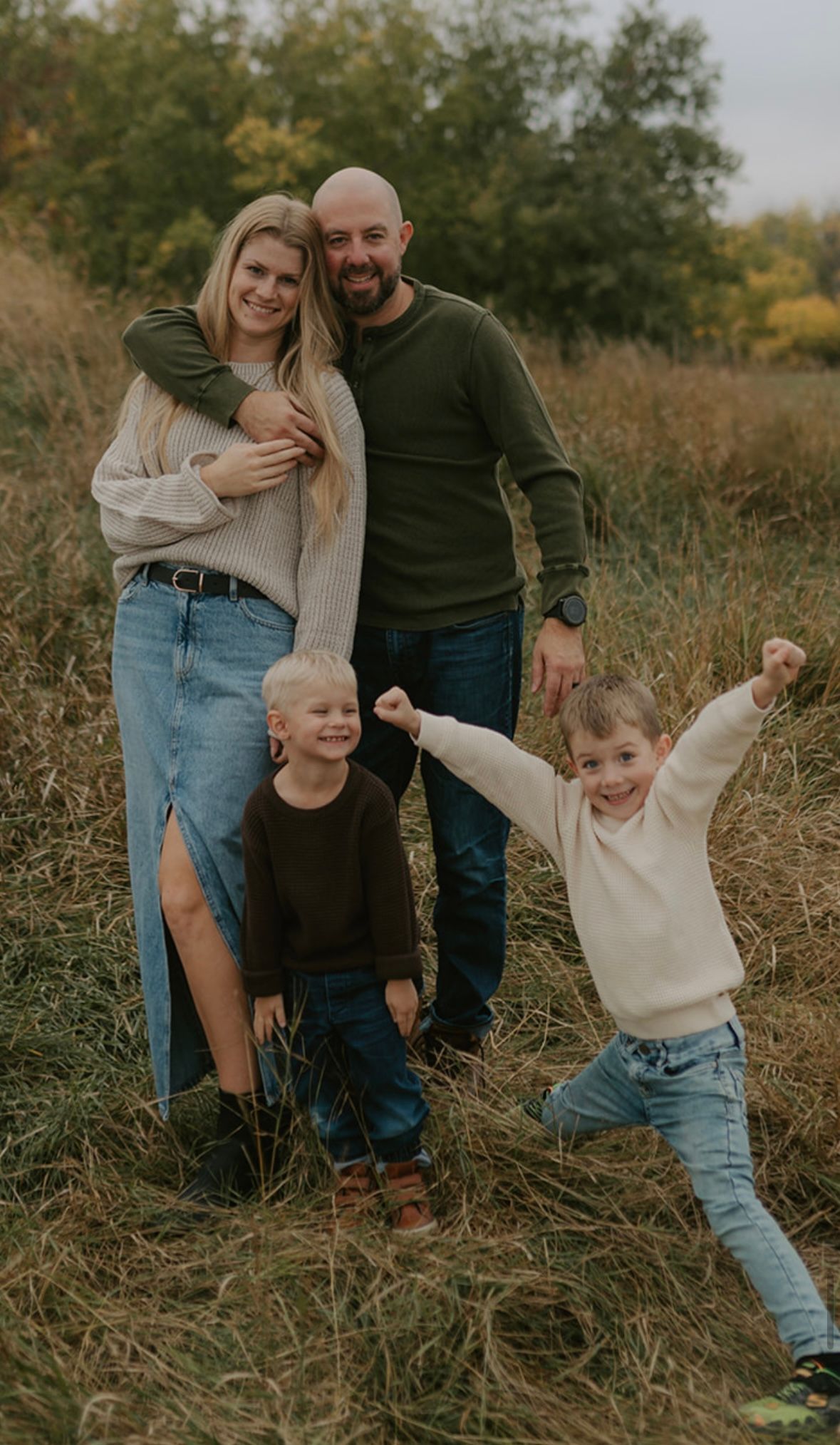 Man with dark hair and glasses, smiling, wearing a burgundy sweater.