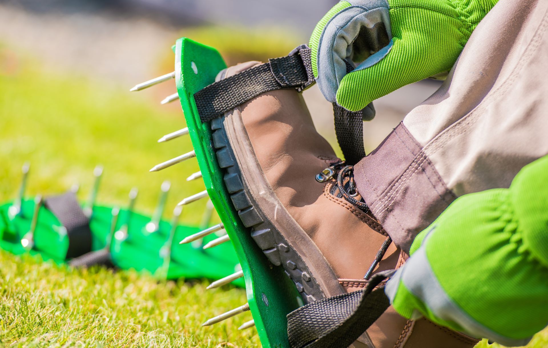 landscaper putting on spiked aerator shoes