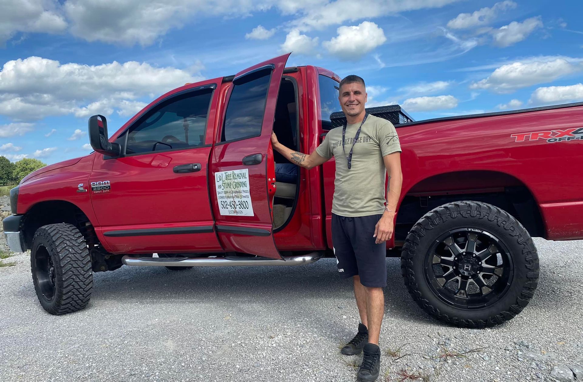 A man wearing a helmet and sunglasses is standing in a field.