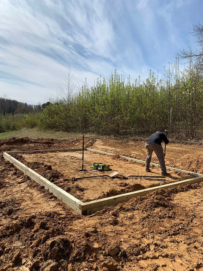 A man is standing in the middle of a dirt field.