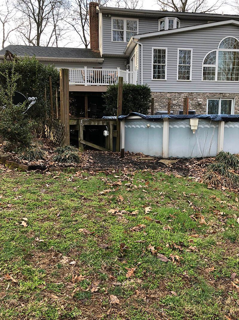 The backyard of a house with a pool and a deck.